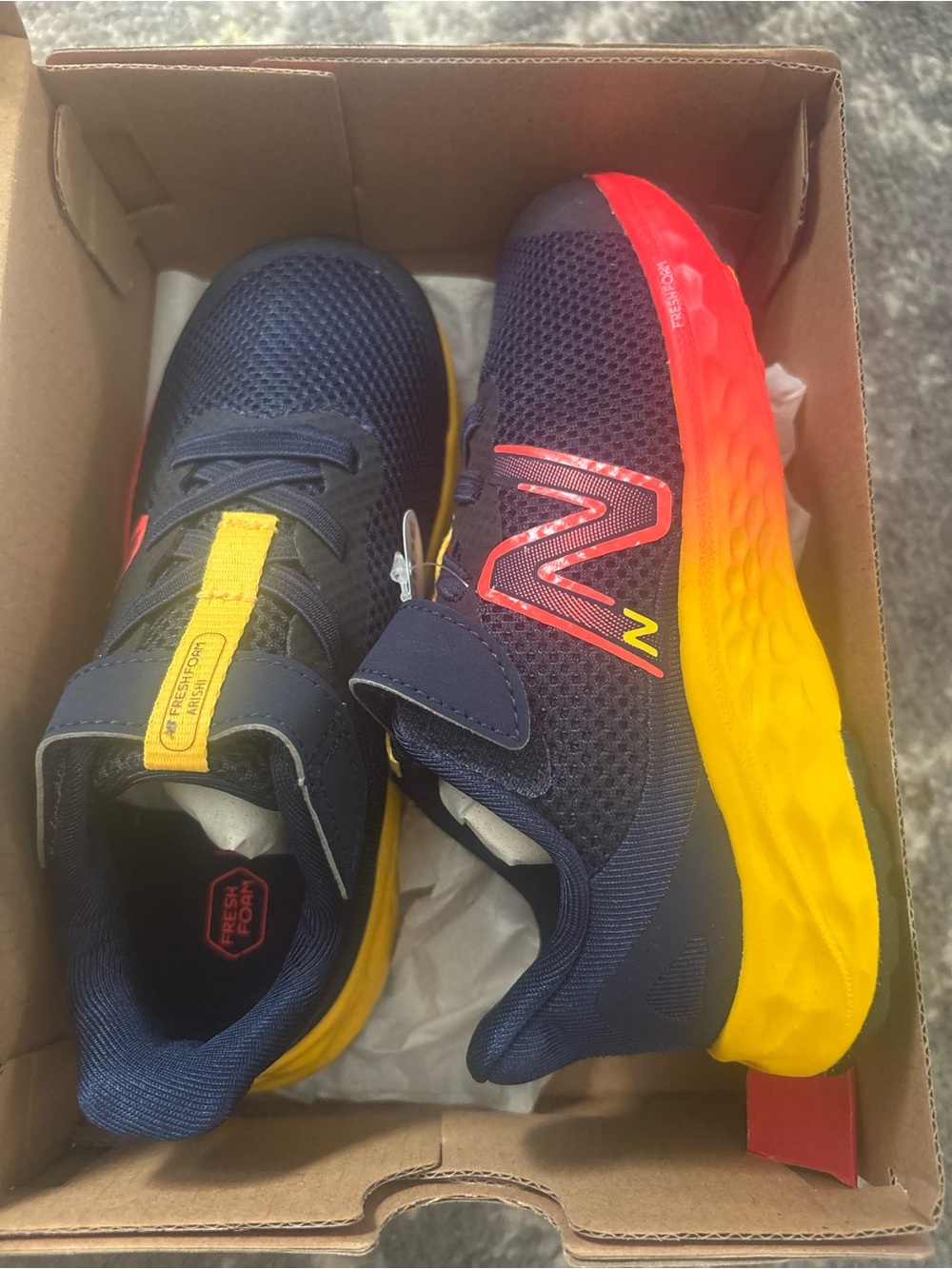 New Balance Kids Navy Sneakers with Red-to-Yellow Gradient Sole